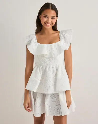 Vit figurnära klänning med volang från Malina 2026